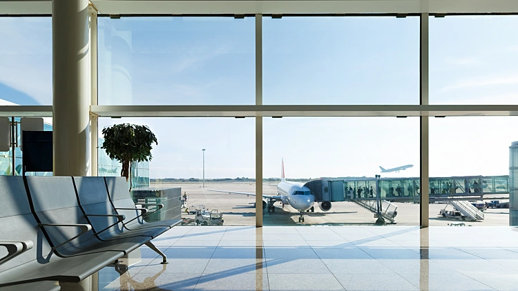 Airport,terminal,,people,going,to,airplane,in,background