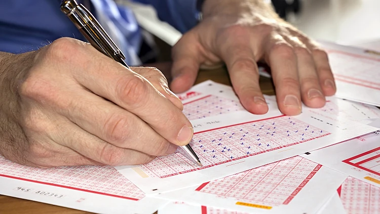 Man,marking,on,lottery,ticket,with,a,pen