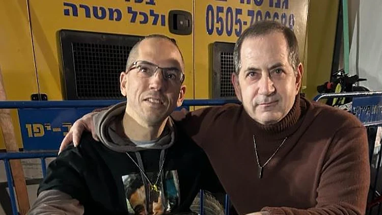 מייסד פרס בראשית סטן פולובץ (מימין) עם דורון זקצר, המחזיק בתמונה של עידן אלכסנדר, אותו אירח בביתו בישראל כחייל בודד