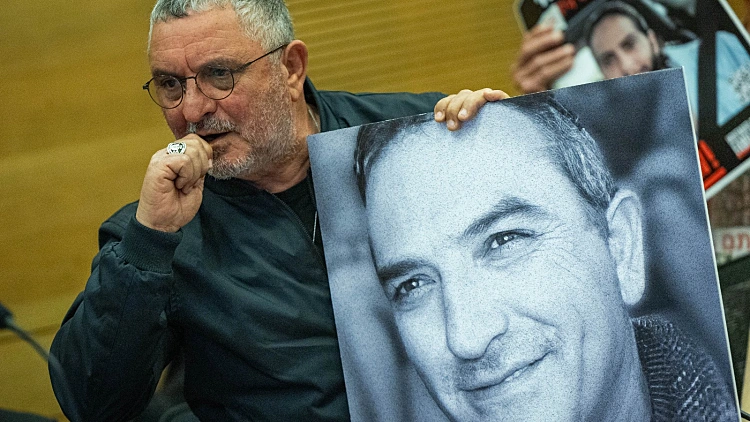 דני אלגרט בכנסת עם תמונת אחיו איציק שנרצח בשבי