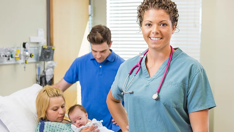 Portrait,of,successful,nurse,standing,with,couple,and,newborn,baby