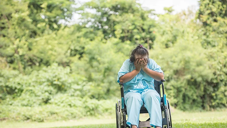 Lonely,elderly,woman,sitting,sad,feeling,on,wheelchair,at,garden