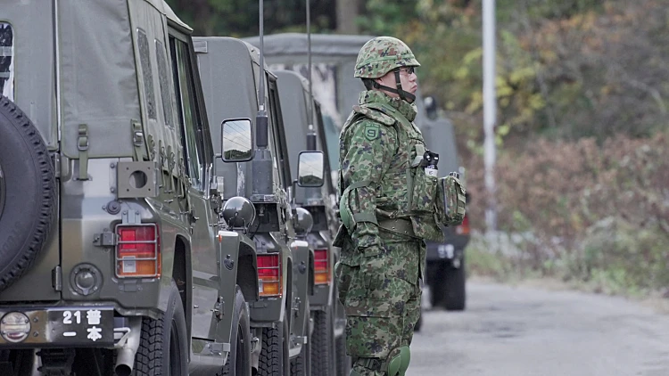 A Member Of Japan Self Defense Forces (jsdf) Stands Next To Military Vehicles During A Practice Setting Up A Bear Trap In Kazuno