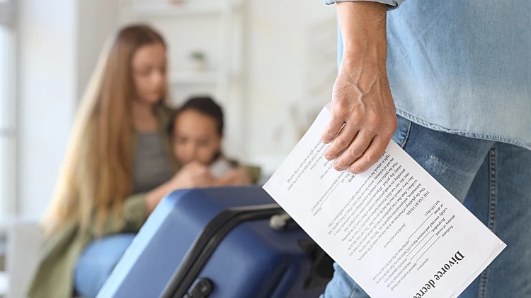 Young,man,with,divorce,decree,and,suitcase,leaving,his,family