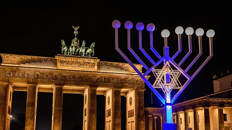 Brandenburg,gate,and,lightning,jewish,menorah,on,a,square,against