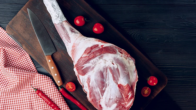 Raw,lamb,leg,on,dark,wooden,board