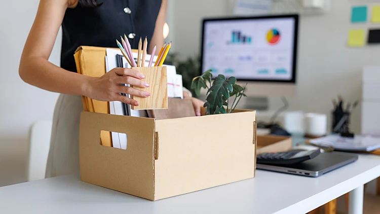 Businesswoman,packing,her,belongings,in,a,cardboard,box,after,being