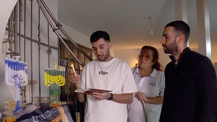 הדלקת נר שלישי עם הלוחם שהפך למשותק ב- 7.10 - וחזר לנגן בפסנתר