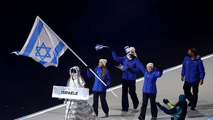 מנהלת המשלחת ירדן הר לב ומריה סניוק, החלקה אומנותית, נושאת את הדגל