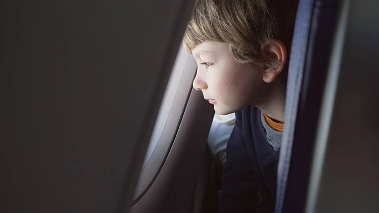 ילד מסתכל מחלון המטוס