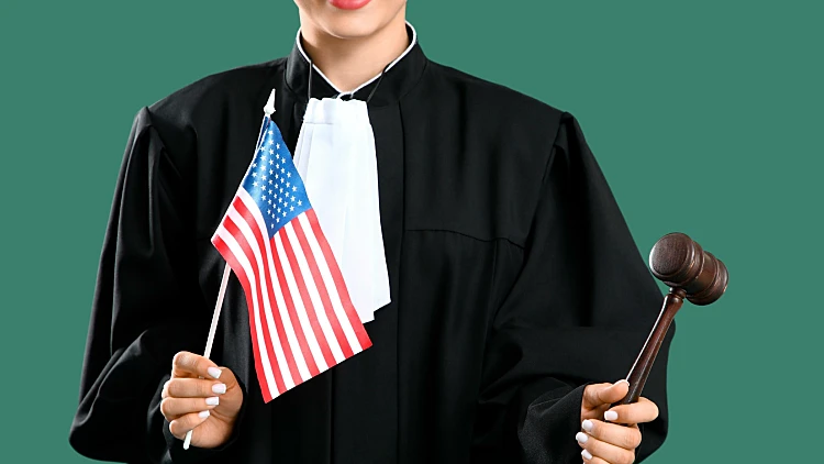 Female,judge,with,gavel,and,usa,flag,on,green,background.