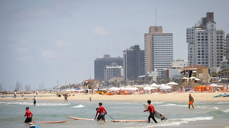 מזג אוויר שמשי בקיץ בחוף הים בתל אביב. בהיר, מתרחצים, שרב, חום