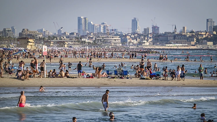 מתרחצים בחוף הים בתל אביב, מזג אוויר בהיר וקיצי
