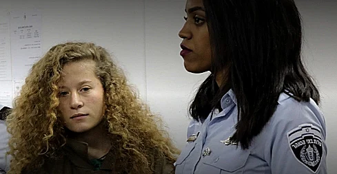 עהד תמימי מובלת על ידי שוטרת לבית המשפט הצבאי באזור יהודה ושומרון רויטרס