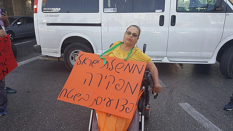 מפגינה במחאת הנכים במחלף הסירה