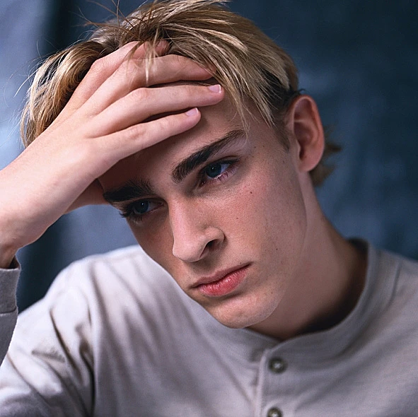 נער מדוכא נשען על היד