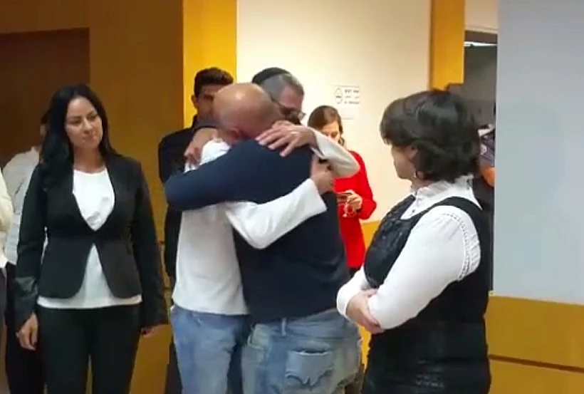 חן אילתי, שהורשע פה אחד מרצח אמו בקיבוץ מחניים, מתחבק עם חברו עמוס בכר לאחר הכרעת דינו