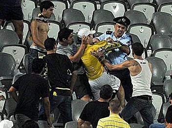 שוטר במהלך עימות אלים עם אוהדי בית