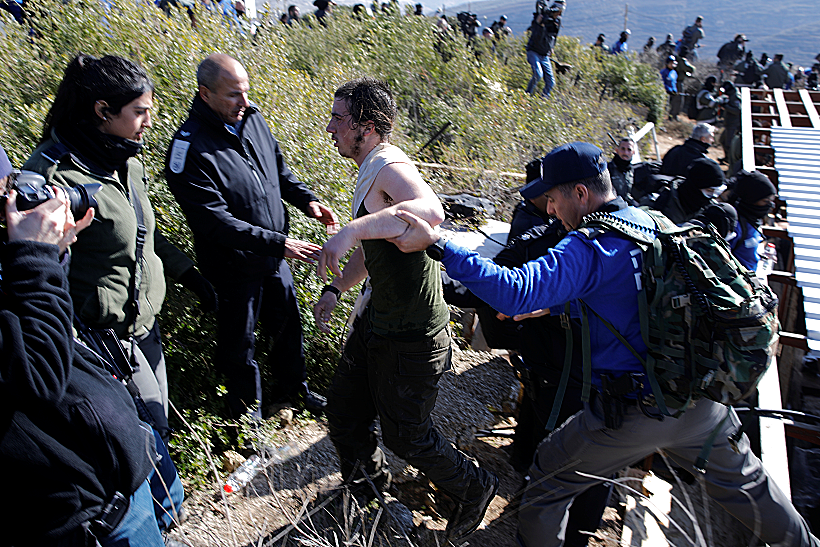 פעיל מפונה בכוח מבית הכנסת במהלך פינוי עמונה