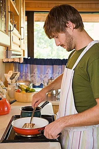 גבר לבוש סינור מבשל