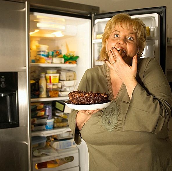 עומדת ליד מקרר פתוח