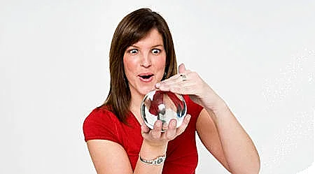 אישה בחולצה אדומה מחזיקה ומתבוננת בכדור בדולח