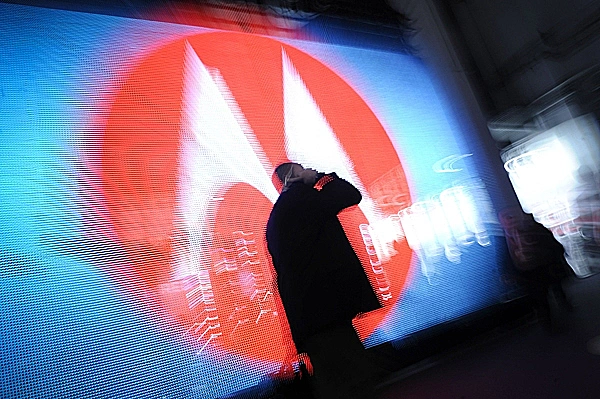 איש משוחח בטלפון על רקע הלוגו של מוטורולה