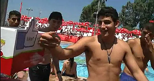 נער מעביר צמיד-Like בכפר הצעירים של קוקה קולה