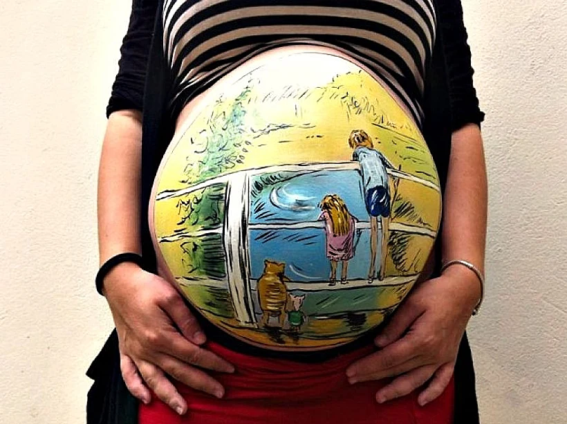 האיש שמצייר על בטנה ההריונית של אשתו