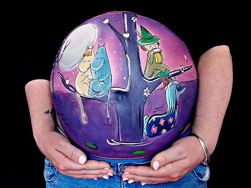 האיש שמצייר על בטנה ההריונית של אשתו