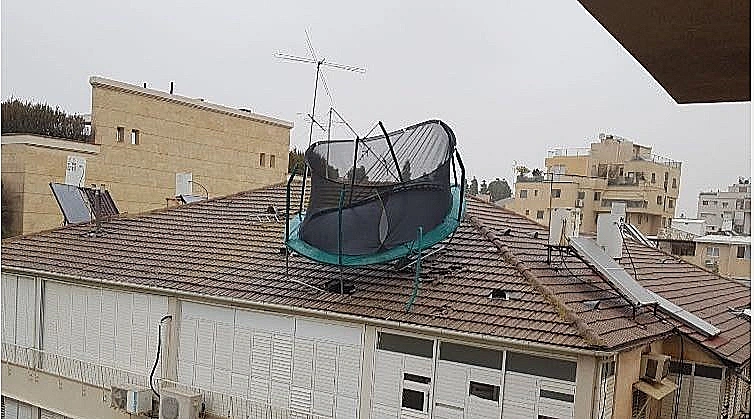 טרמפולינה שעפה כתוצאה מהרוחות ופגעה בבניין בבני ברק, כשהיא גורמת לחור בגג הרעפים
