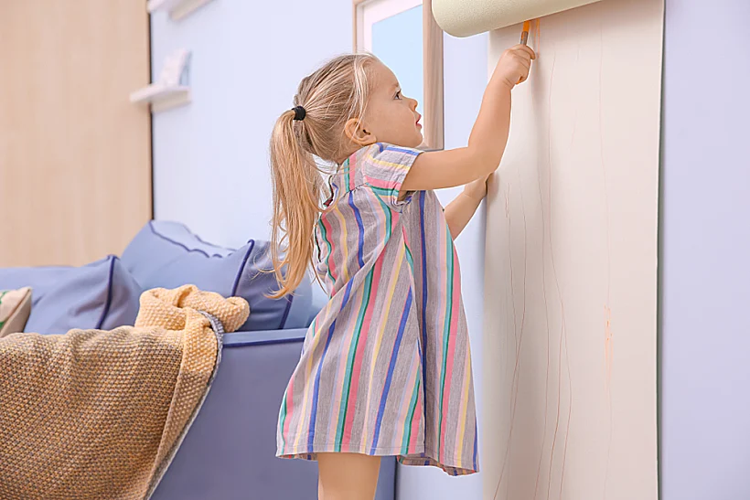 Little,cute,girl,drawing,on,paper,roller,indoors