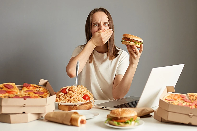 Portrait,of,sick,overeating,woman,sitting,at,table,in,front