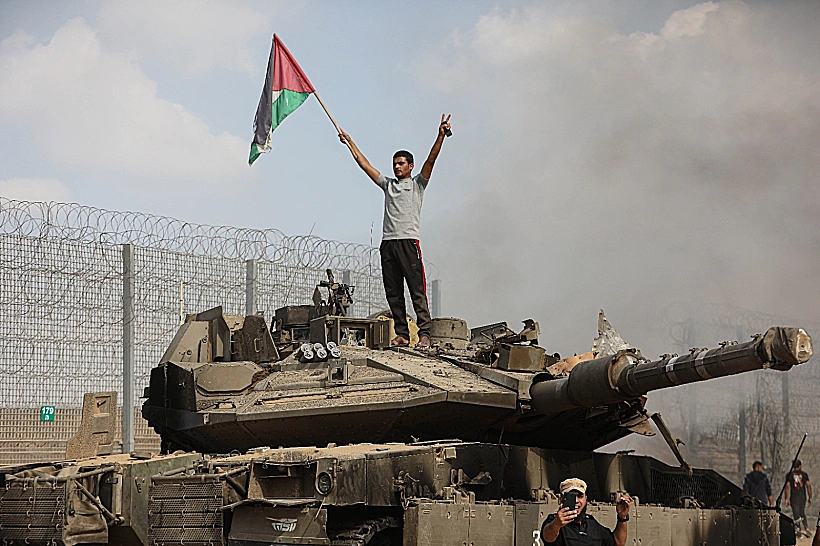 תושב עזה חוגג על טנק ישראלי בח'אן יונס