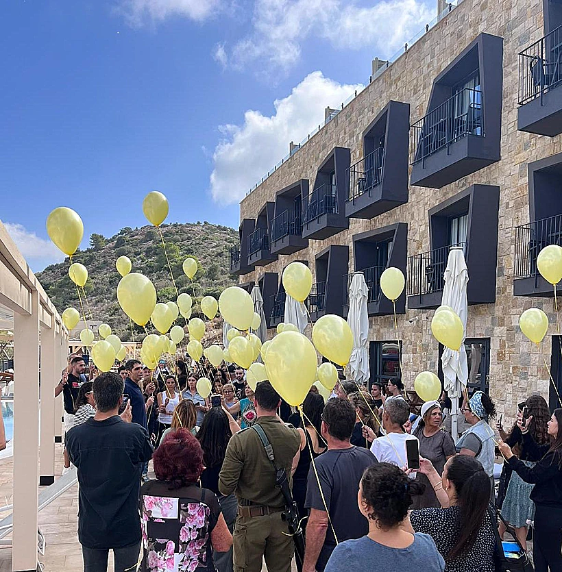 מפונים ועובדים מפריחים יחד בלונים למען החטופים במלון קדם