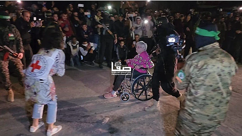 דיצה הימן מובלת על כיסא גלגלים לרכב הצלב האדום