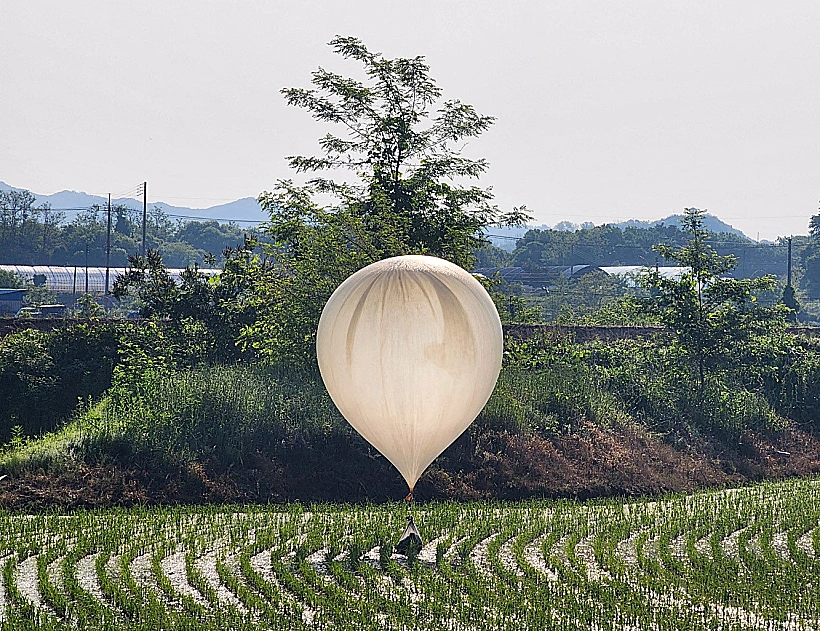 A Balloon Believed To Have Been Sent By North Korea, Carrying Various Objects Including What Appeared To Be Trash And Excrement, Is Seen Over A Rice Field At Cheorwon