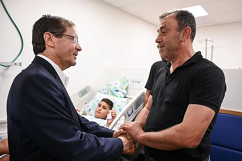 נשיא המדינה הרצוג עם אדם אלשאער, אחד מפצועי ירי חיזבאללה על מג'דל שמס