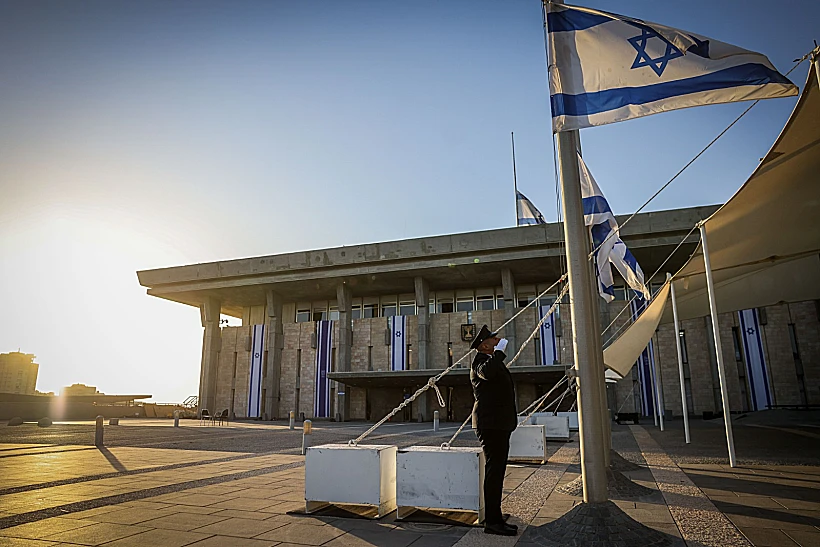 יום אבל לאומי לטבח 7 באוקטובר. איש משמר הכנסת מוריד את הדגל חצי התורן
