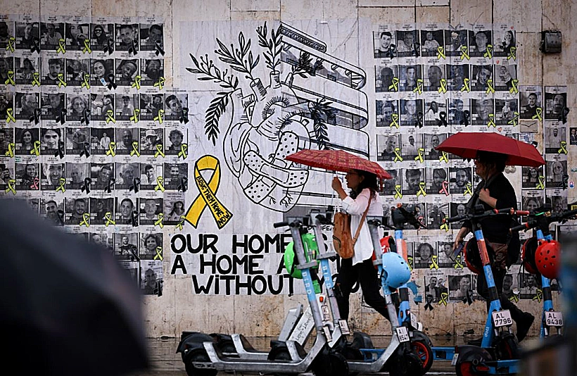 יום גשום בתל אביב, כשברקע תמונות חטופים