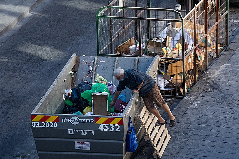 עוני אדם מלקט מתוך פח בירושלים