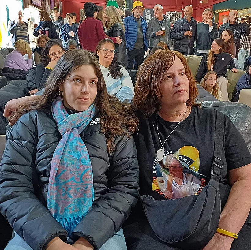 רעיה רותם ובתה הילה, ששוחררו בעסקה הראשונה, צופות במשדר שחרור החטופים בפאב בבארי