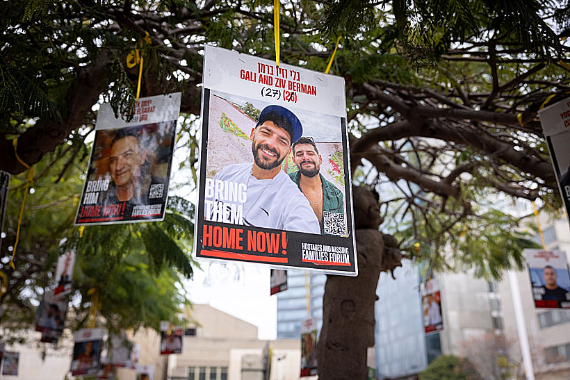 שלט עם תמונתם של גלי וזיו ברמן בכיכר החטופים