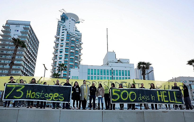מפגינים עם שלטים לציון 500 יום למלחמה ו-73 חטופים בעזה בתל אביב