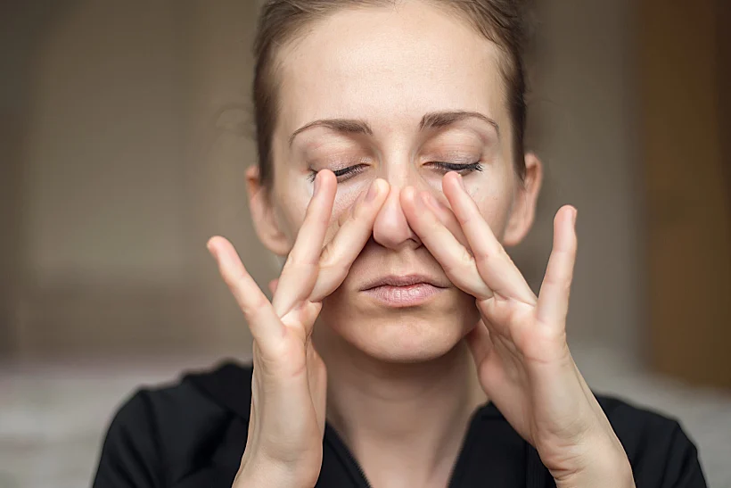 A,young,woman,touches,her,nose,with,her,fingers,because