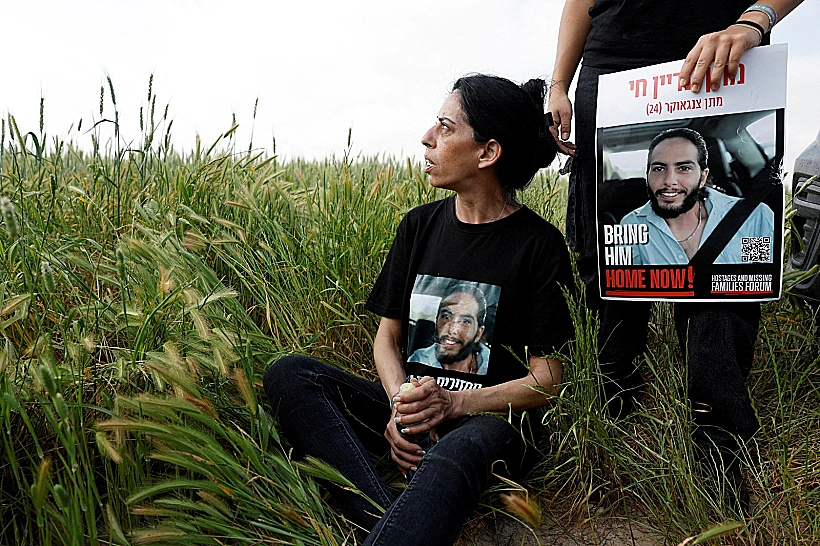 עינב צנגאוקר עם תמונת בנה מתן ליד ניר עוז, גבול עזה