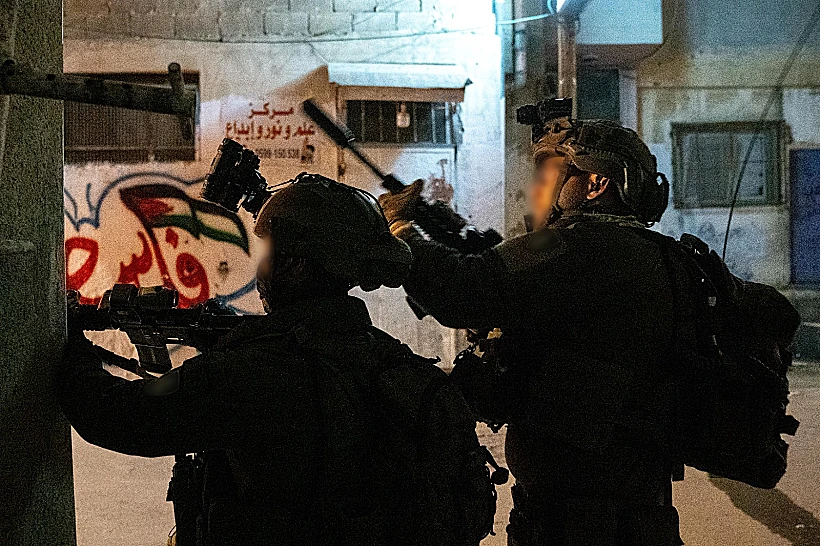 כוחות צה"ל בשכם, על רקע ציור של דגל פלסטין