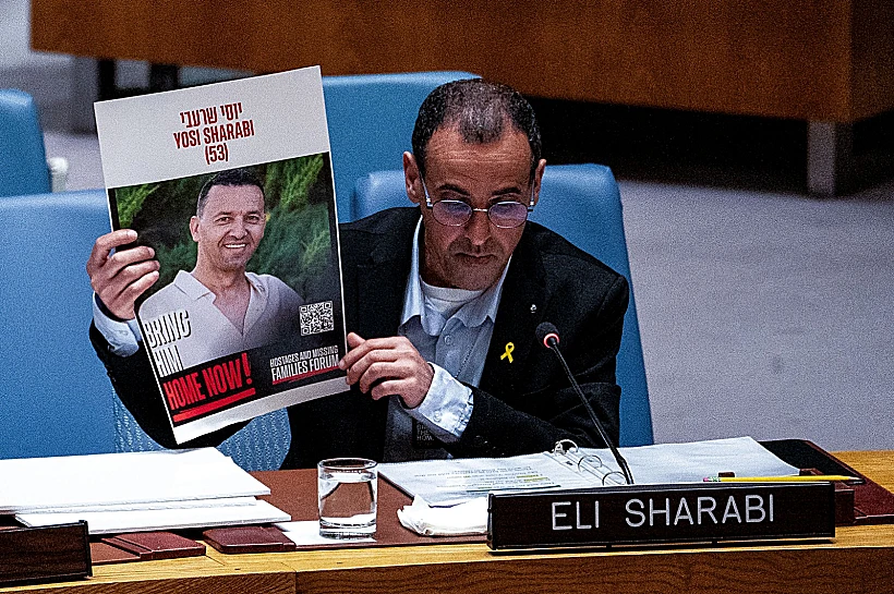 אלי שרעבי עם תמונת אחיו יוסי במועצת הביטחון של האו"ם