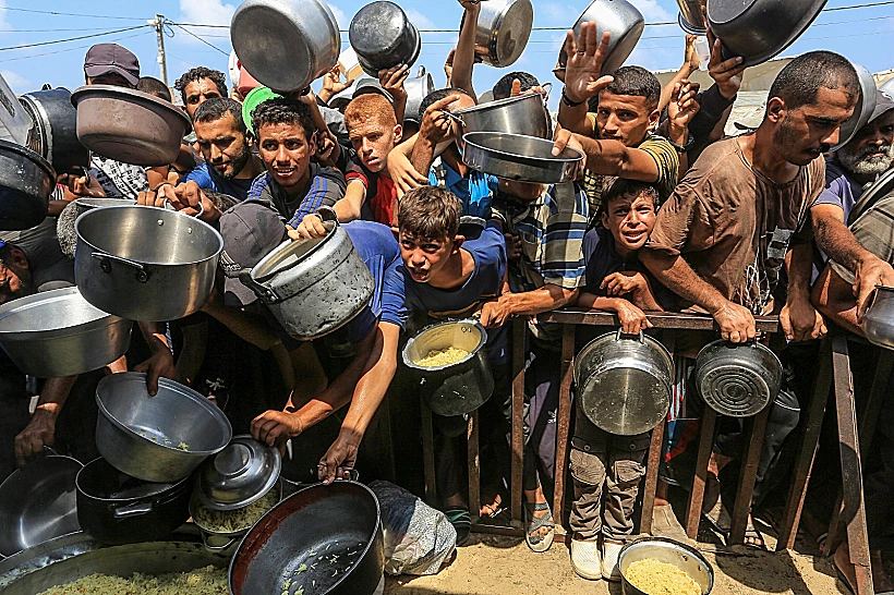 פלסטינים בתור לקבלת מזון בח'אן יונס, דרום רצועת עזה