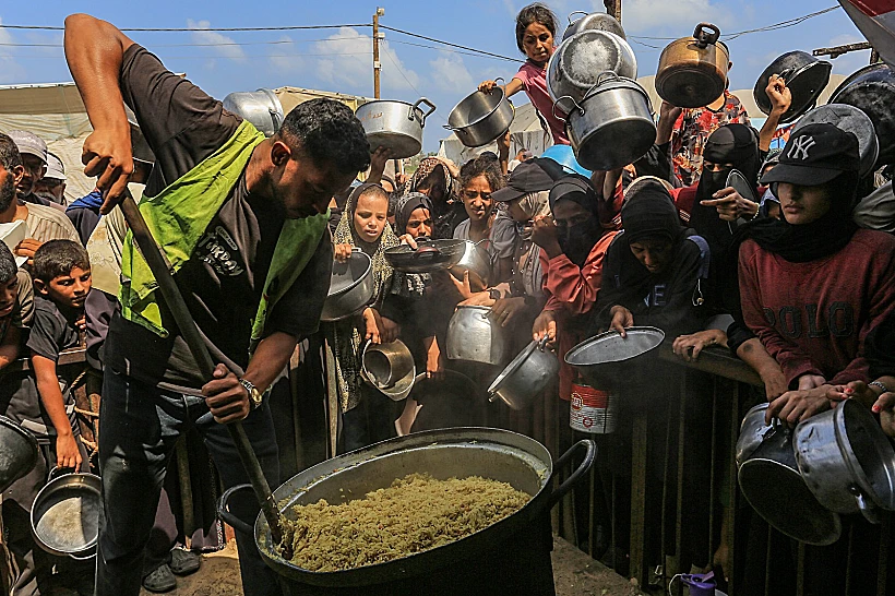 פלסטינים בתור לקבלת מזון בח'אן יונס, דרום רצועת עזה